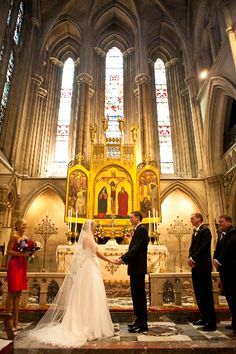 a bride and groom standing in front of the alter