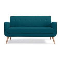 a blue couch sitting on top of a white floor next to a wooden leg chair