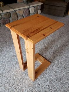 a wooden table sitting on top of a carpeted floor next to a fire place