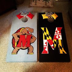 two cornhole boards decorated with the letters m and m