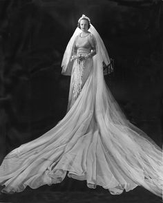 an old black and white photo of a woman in a wedding dress with veil on her head