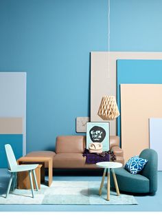 a living room with blue walls and furniture on the floor, including two chairs and a couch