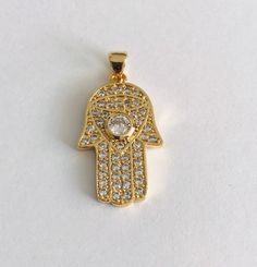 18K GOLD FILLED HAMSA PENDANT WITH WHITE CZ. FOR GOOD LUCK ,PROSPERITY AND PROTECTION. PENDANT : 29 mm x 15 mm 18K GOLD FILLED DIJE DE MANO DE FATIMA CON CZ BALNCO. PARA PROSPERIDAD, BUENA SUERTE Y PROTECCION. DIJE: 29 mm x 15 mm Gold Cubic Zirconia Jewelry With Evil Eye, Gold Cubic Zirconia Jewelry With Evil Eye Detail, Protection Pendant, Evil Eye Hand, Hamsa Pendant, For Good Luck, Pompano Beach, Evil Eye, Good Luck