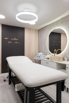 a spa room with a large mirror above the sink and a white table in front of it