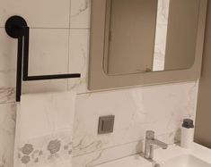 a bathroom with a sink, mirror and towel rack