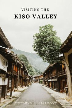 an alley way with trees and buildings in the background, text overlay reads visiting the kiso valley