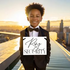 a young boy in a tuxedo holding a sign that says king and siccrity