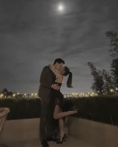 a man and woman are kissing in the moonlight