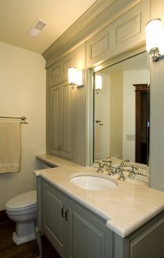 a bathroom with a sink, toilet and mirror