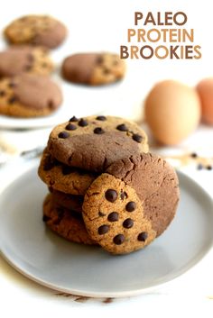 three chocolate chip cookies stacked on top of each other with eggs in the back ground