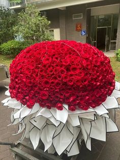 a large bouquet of red roses on top of a cart