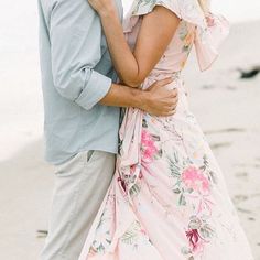 a man and woman embracing each other on the beach