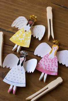 paper angel craft with clothes pins and pegs on the table next to them,