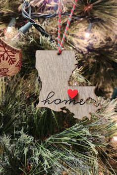 a wooden ornament hanging from a christmas tree with the word home on it