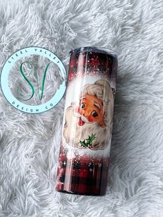 a christmas themed tumbler sitting on top of a white blanket