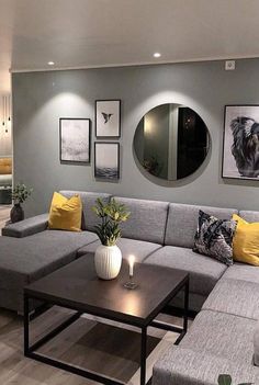 a living room with grey couches and yellow pillows