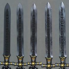 four large knives with gold handles are lined up in a row on top of each other