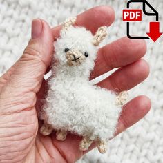 a small white stuffed animal being held in someone's hand