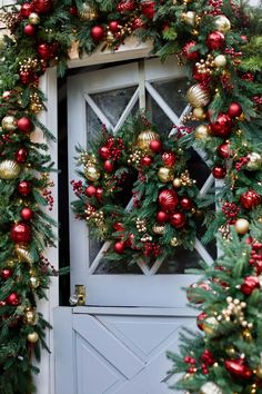 christmas wreaths and ornaments are hanging on the front door to create a festive display