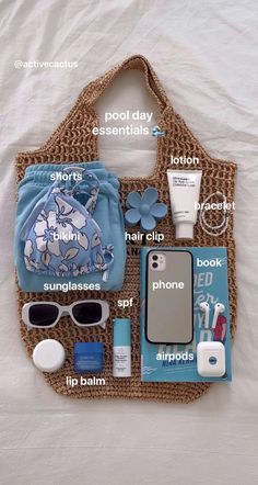 the contents of a purse laid out on top of a white sheet with blue flowers