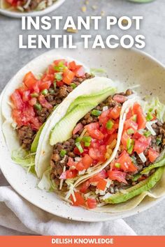 two tacos with lettuce, tomatoes and other toppings in a white bowl