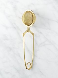 a golden metal object on a white marble counter top with a wire attached to it