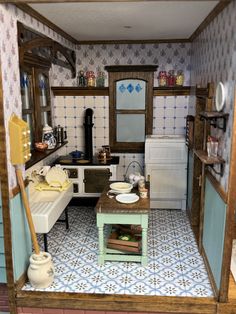 a dollhouse kitchen with blue and white tiles on the floor, including an oven