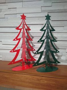 three metal christmas trees sitting on top of a wooden table