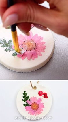 someone is painting flowers on a white plate