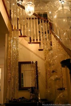 some balloons are hanging from the ceiling near a mirror and stairs with lights on them