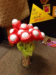 a vase filled with golf balls on top of a table