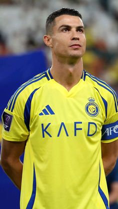 a soccer player is looking up at the sky with his hand on his hip while standing in front of an audience