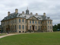 a large stone building sitting on top of a lush green field