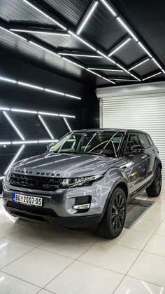 a silver car parked in front of a garage door with lights on the side of it