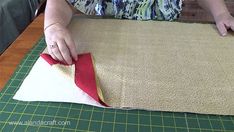 a woman cutting fabric on top of a table