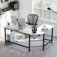 an office desk with a computer and headphones on it in front of a window