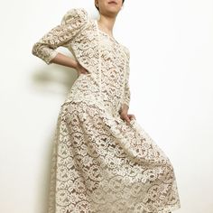 "This is a cocktail ivory cream lace dress with faux pearl embellishment. The dress features a drop waistline with gorgeous decorative lace around it, it has a square neckline with faux pearls trim. Two rows of pearly trim run down to the waistline. Long puff sleeves are gathered with pearly buttons.  The dress is tea length (below the knee) and the fabric is see-through. Brand: Maison Missy House Canada In excellent condition, no tears Estimated Size M/L  (model in pictures is size S) MEASUREME Fitted Beige Lace Dress With Lace Patchwork, Elegant Lace Dress With Square Neck For Spring, Elegant Beige Lace Dress With Scalloped Lace, Elegant Beige Lace Dress With Scalloped Details, Elegant Square Neck Lace Dress For Spring, Elegant Beige Scalloped Lace Dress, Cream Lace Dress With Lace Collar For Spring, Feminine Lace Dress With Lace Sleeves, Elegant Lace Dress With Lace Collar For Daywear