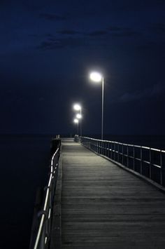 a pier at night with street lights on it