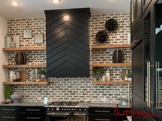 a kitchen with black cabinets and white brick backsplashing, built in shelving above the stove