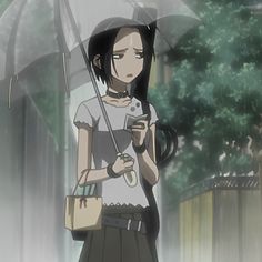 a woman holding an umbrella while standing in the rain