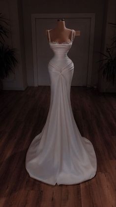 a white wedding dress on display in a room