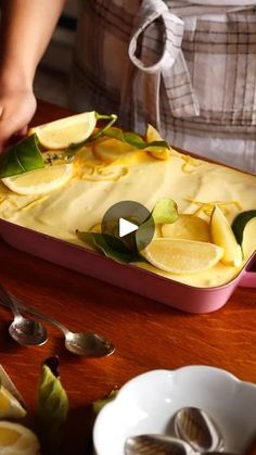 a person cutting up lemon slices on top of a pan with spoons next to it