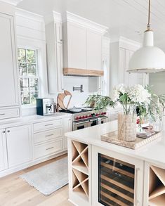 a kitchen filled with lots of white cabinets and counter top space next to a wine rack