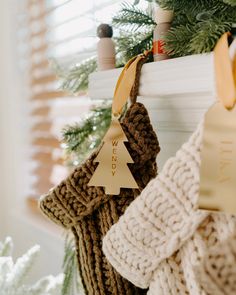 christmas stockings hanging from a fireplace with the words merry written on one side and a tree ornament in the other