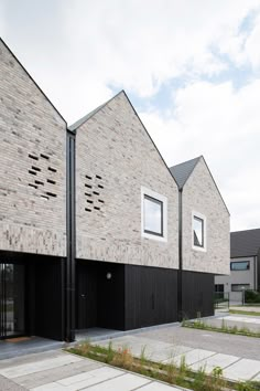 two brick buildings with black doors and windows on the side of each building are facing opposite directions