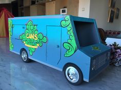 an ice cream truck is painted blue and has green designs on the side, along with pink flowers