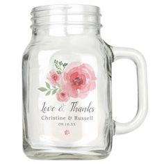 a glass mason jar filled with water and pink flowers on the inside, says love & thanks