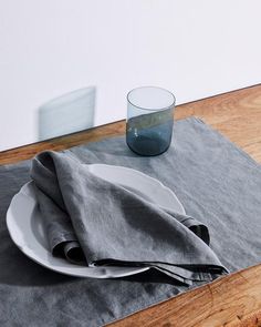 a place setting with napkins and a glass on the table