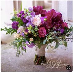 a bouquet of purple and white flowers in a vase