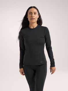 a woman in black top and leggings with her hands on her hips, looking at the camera